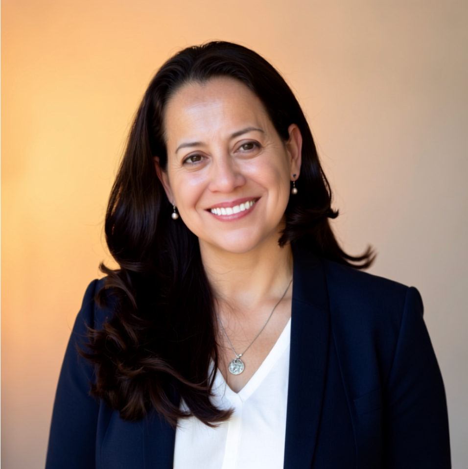 Jannette Cano Schenk, executive coach and leadership consultant, smiling in a navy blazer and white top